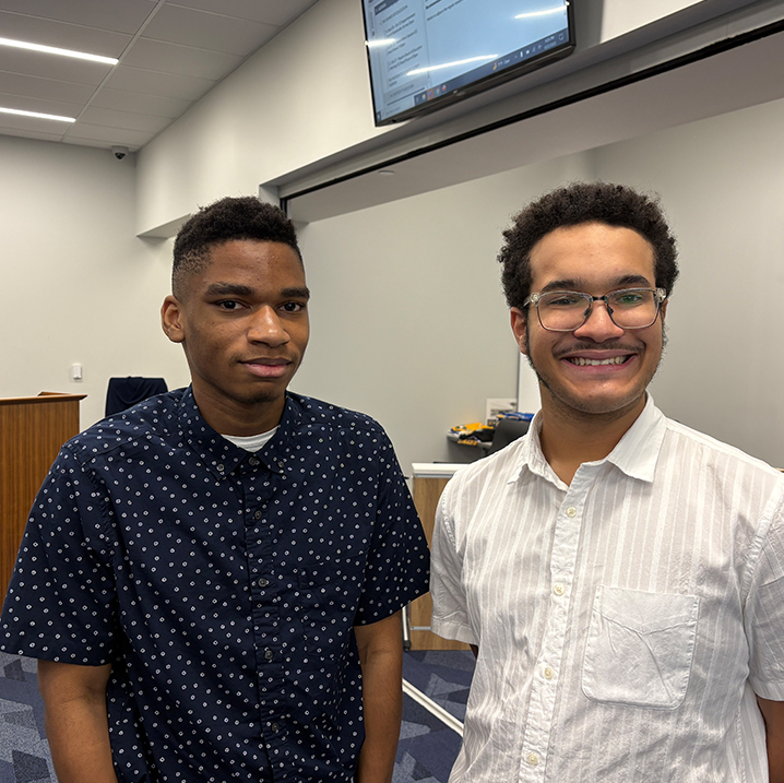 Two young men in collared shirts smile .