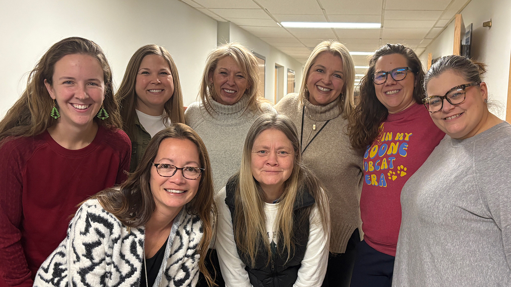 The Special Education Leadership Team stands in a huddle, smiling.
