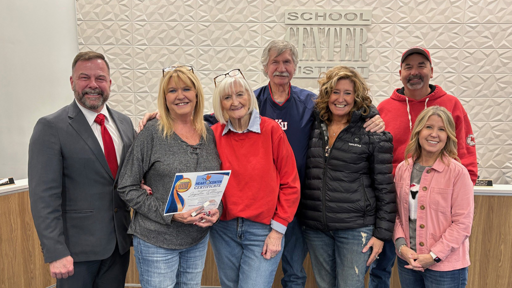 Superintendent Dr. Troy Hogg stands with Heart of Center award winner Jackie Williamson, her family, and Board of Education Chair Marcie Calvin.
