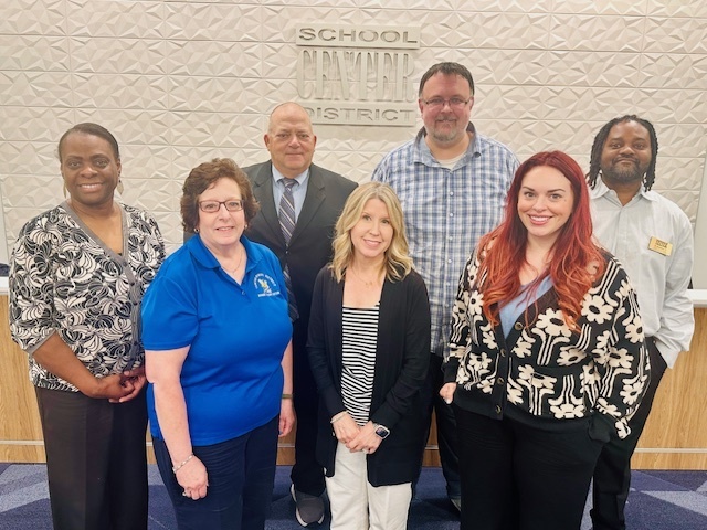 Center School District Board of Education stands in the front of the boardroom at Indian Creek Elementary School.