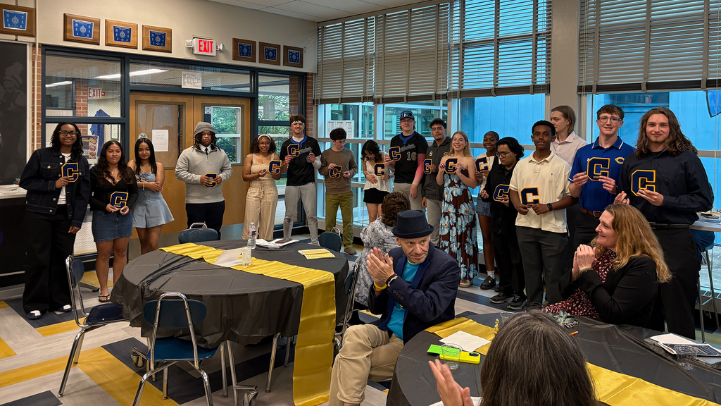 CHS Seniors stand in a line in front of the cafeteria with their academic letters and pins.