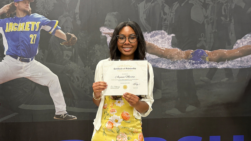 Aiyana Martin stands with certificate for the John T. Belcher Scholarship.