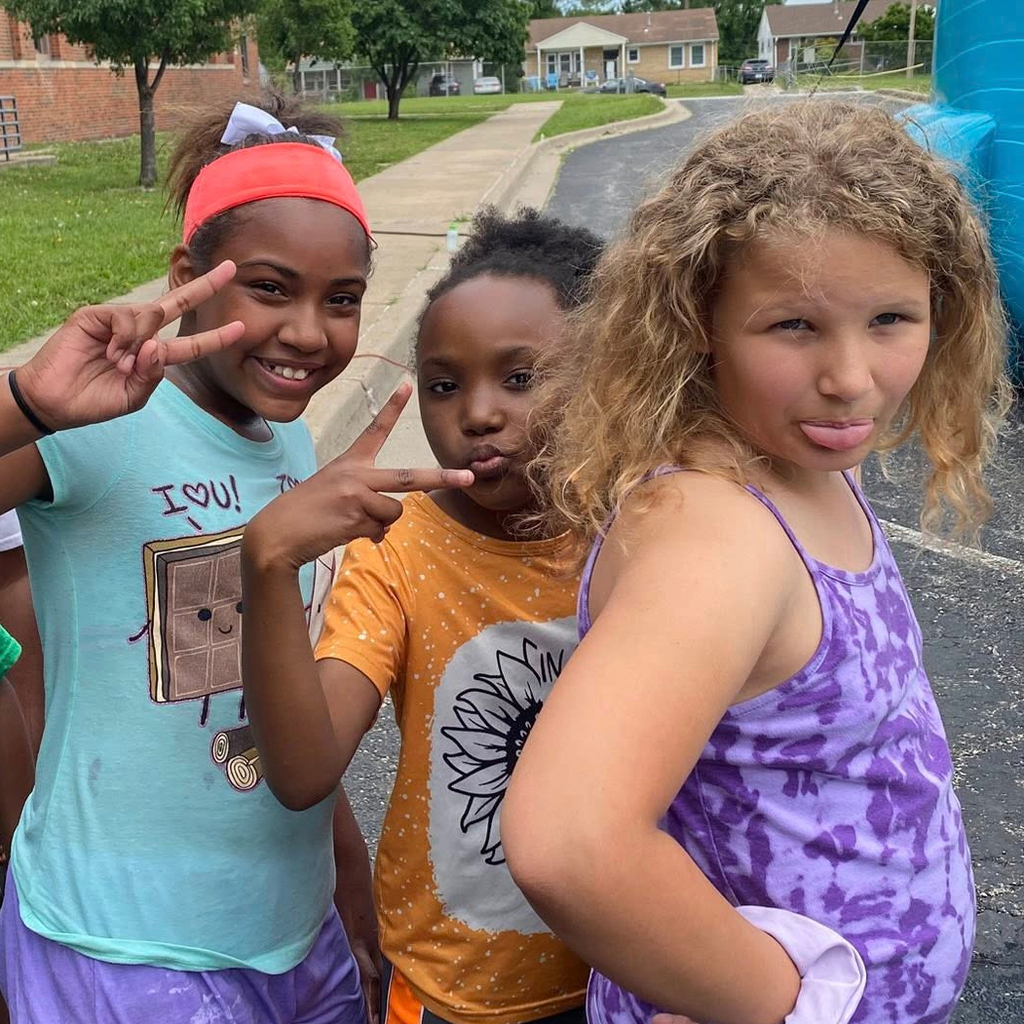 Three Center Elementary students stand on the blacktop in front of the school.