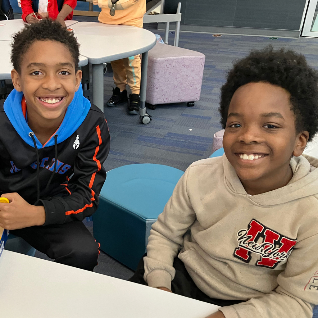 Two Indian Creek Elementary students sit, smiling.