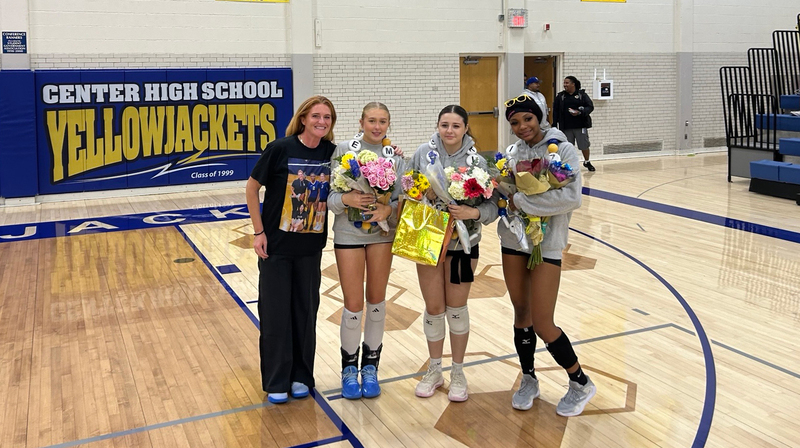 Head Coach Megan Couch stands with varsity volleyball seniors.