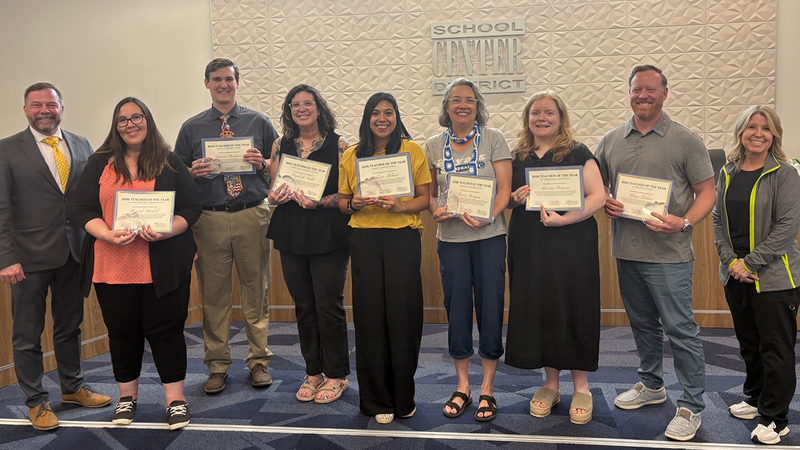 Teacher of the Year honorees stand with the Superintendent and Board of Education Chair in front of the board dias.