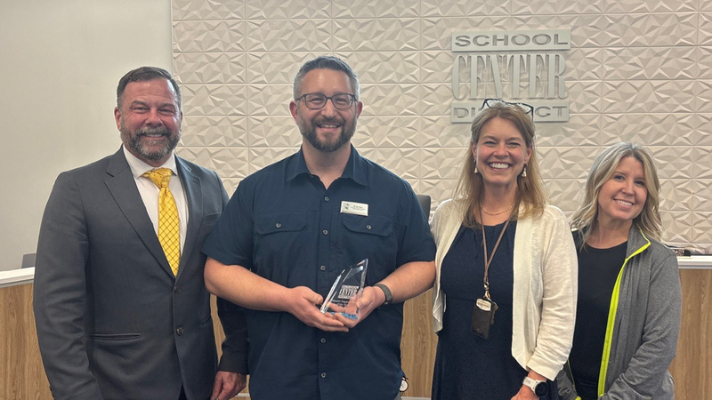 Staff of the Year Kyle Stern with the Superintendent, Assistant Superintendent, and Board President.