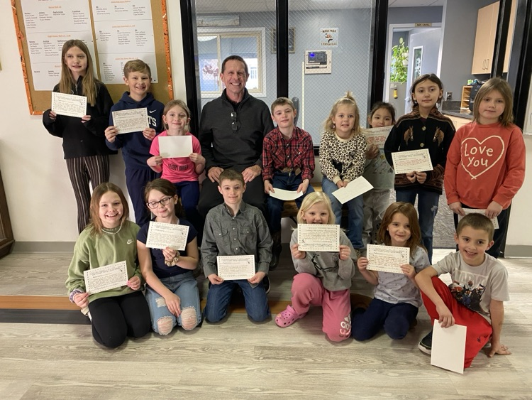 Students holding certificates surrounding the principal