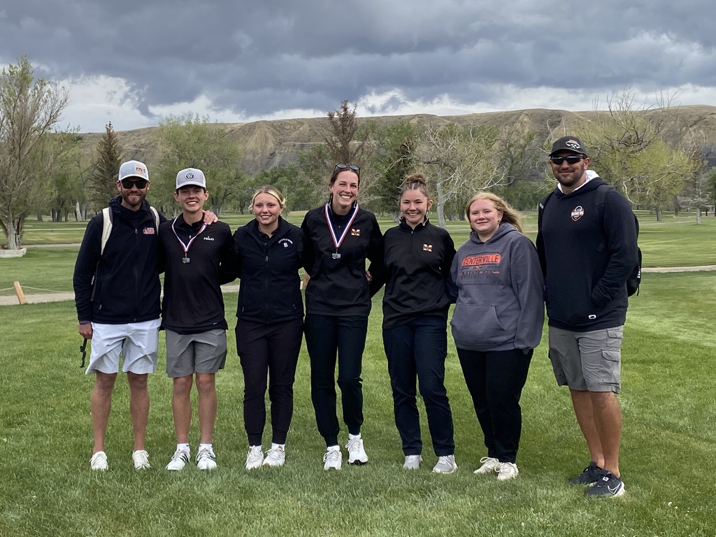 5 golfers and 2 coaches on a golf course