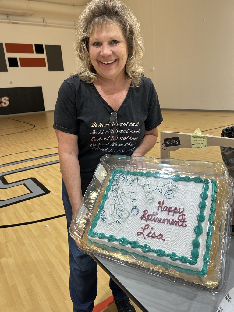 Mrs Navarro holding a cake w/ "Happy Retirement Lisa"