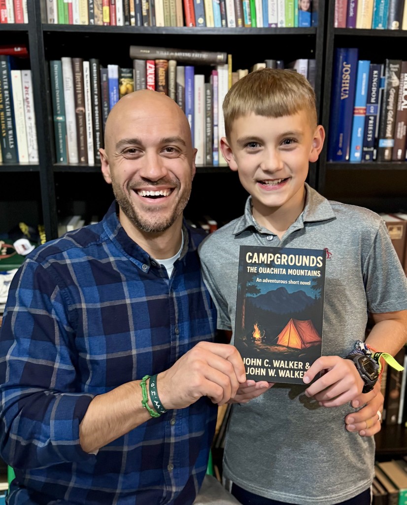 Dr. Walker & Colin Walker holding their published book.
