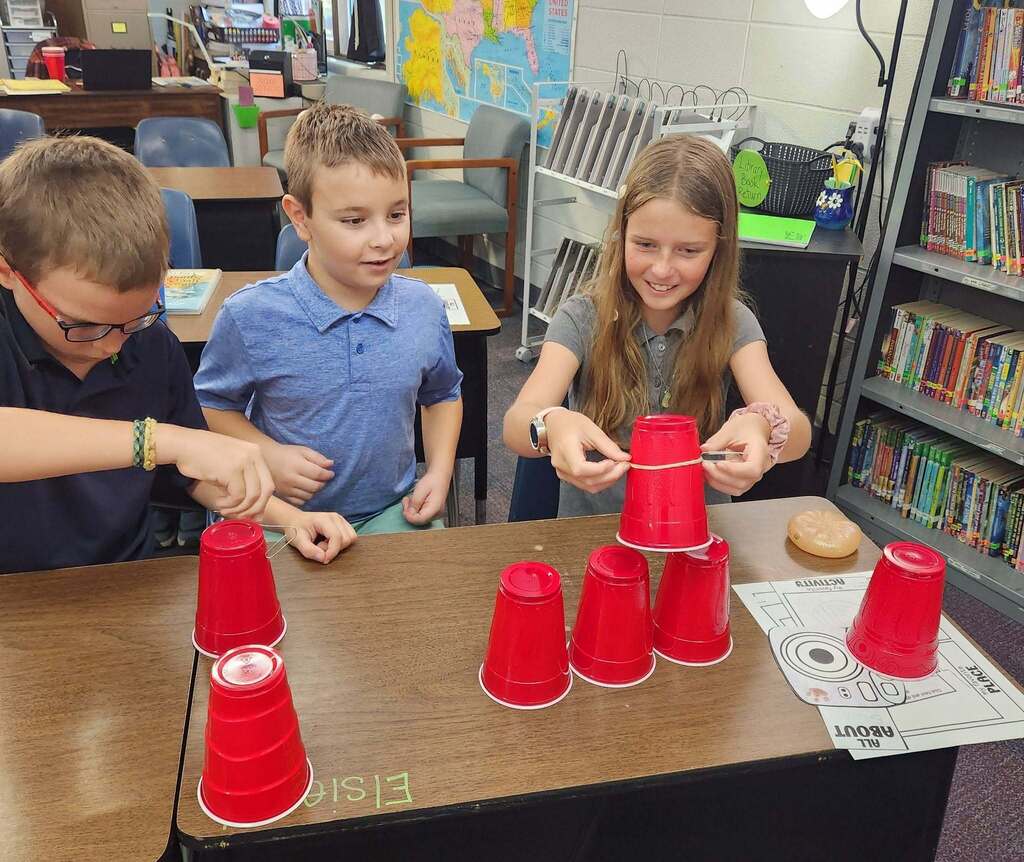 Using rubberbands and paper clips to lift the cups.