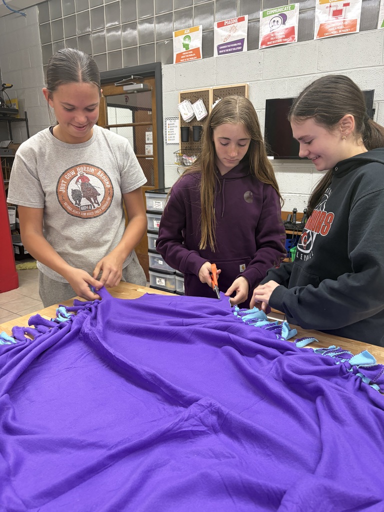 Students making a tie blanket