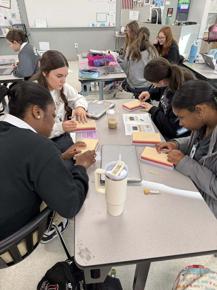 four studetsn practicing with needles