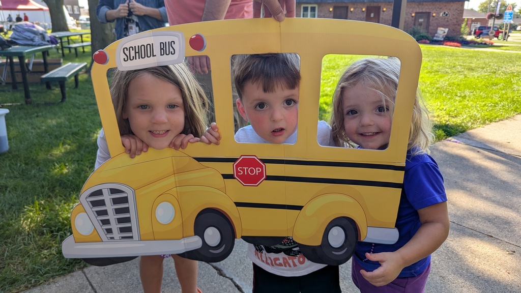 Sabers posing with a school bus