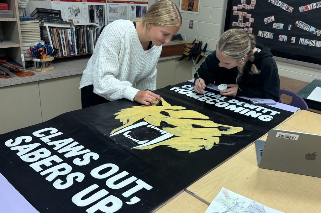 Saber artists painting Homecoming banners for auction