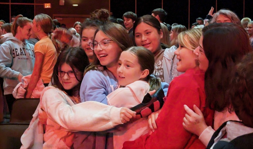Students hugging during assembly