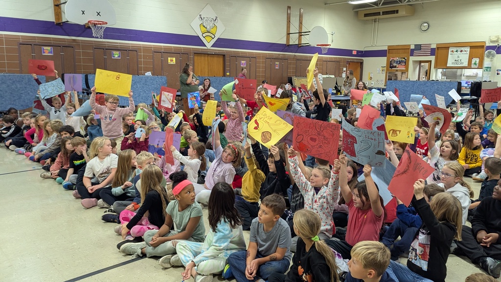 Students showing the signs they made to welcome Coach Sloth
