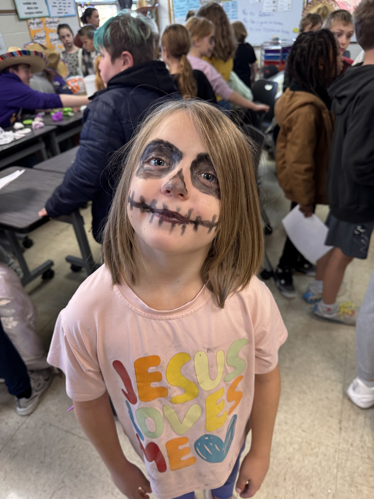 Third grade students with faces painted like skeletons to celebrate Dia de los Muertos