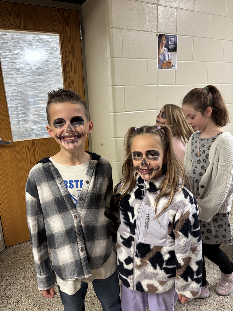 Third grade students with faces painted like skeletons to celebrate Dia de los Muertos