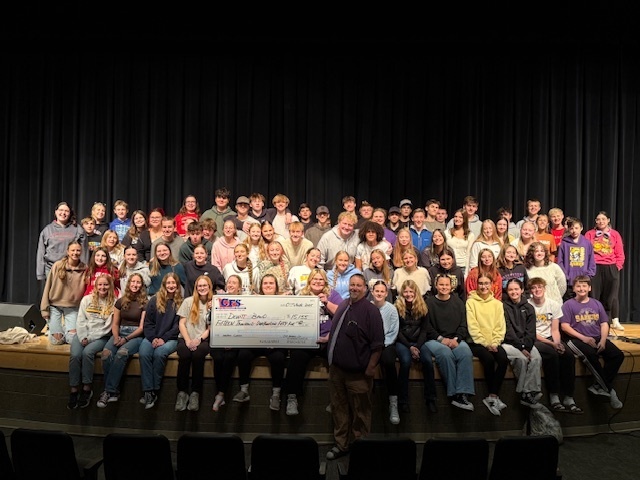CDHS band holding giant check for $15,000 raised during mattress sale fundraiser