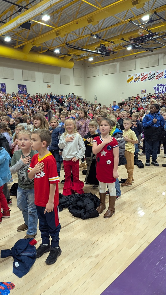 Students with hands over their hearts saying the Pledge of Allegiance 