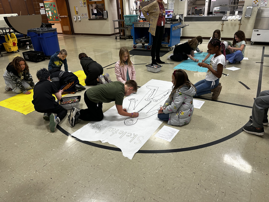 Students drawing life-size skeletal systems