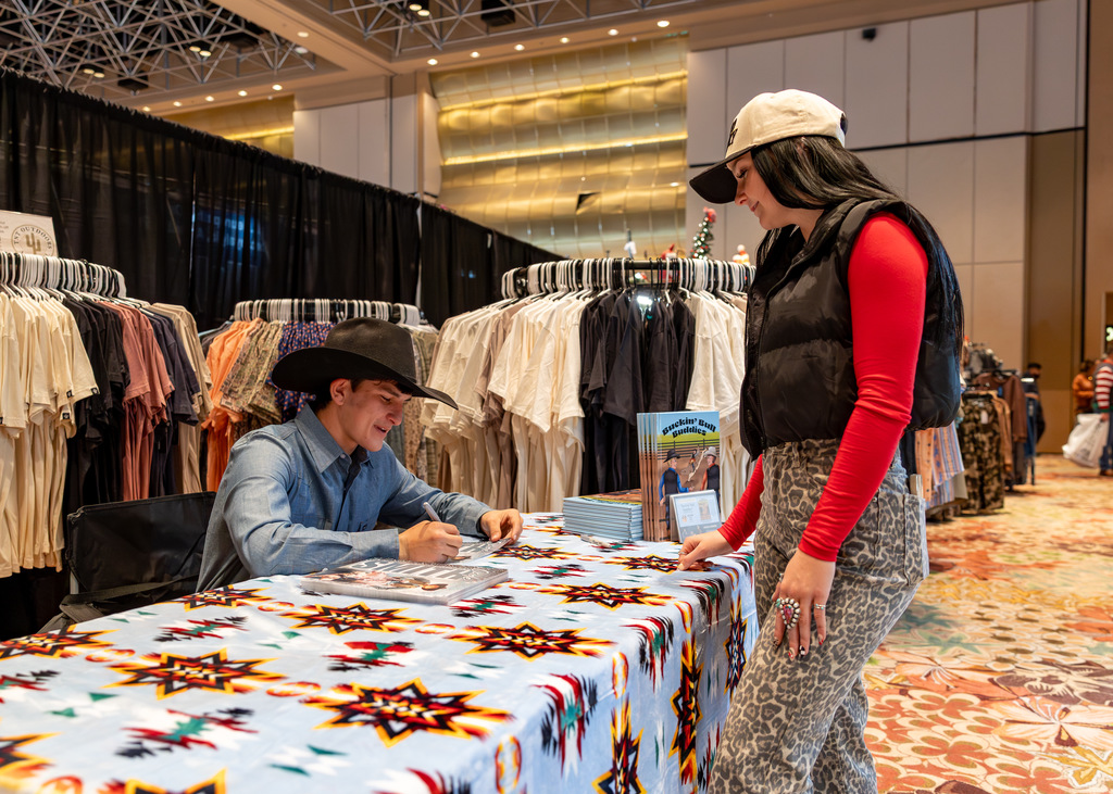 Cade signing copies of Katlin's book at the National Finals Rodeo in Las Vegas
