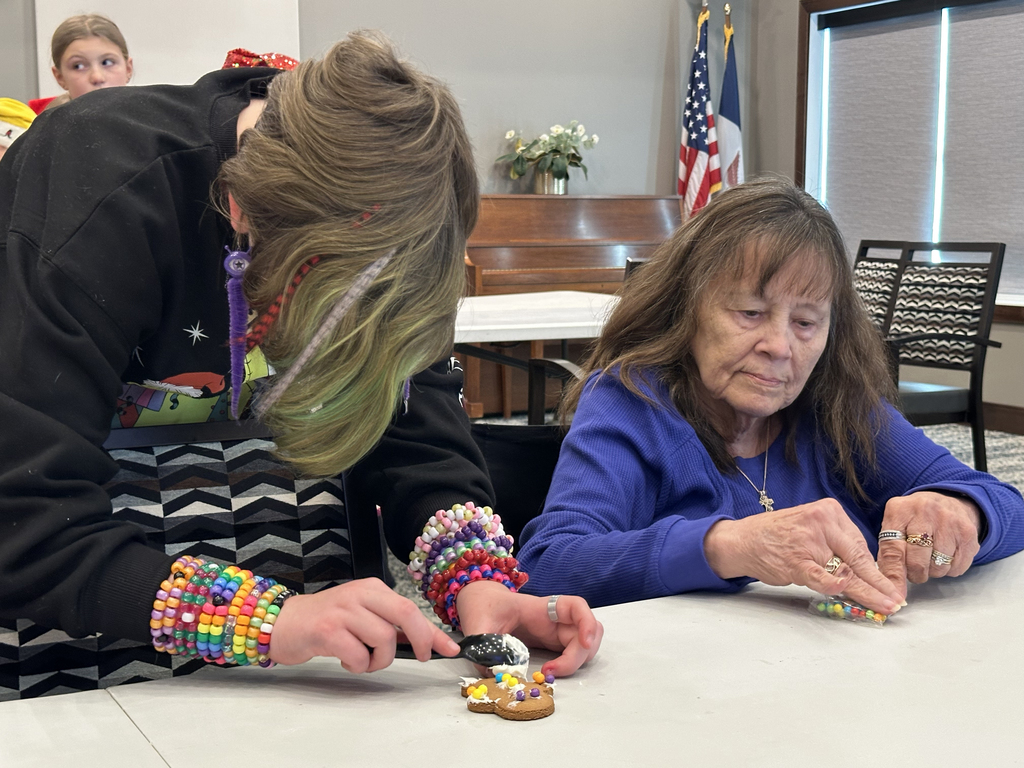 5th Grade Kindness Crew helping residents build gingerbread houses