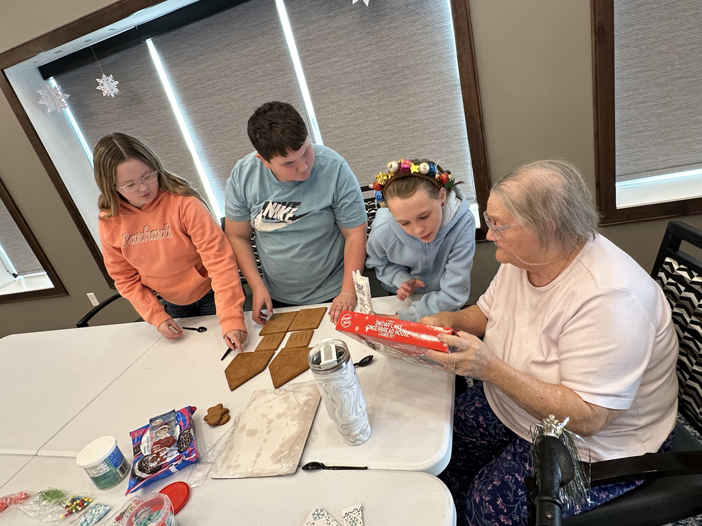 5th Grade Kindness Crew helping residents build gingerbread houses