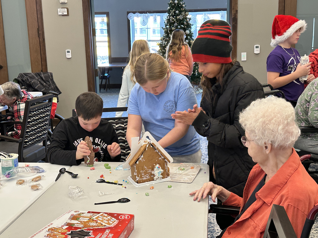 5th Grade Kindness Crew helping residents build gingerbread houses