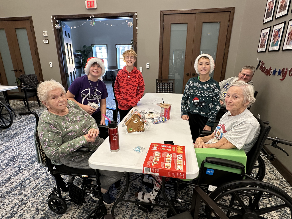 5th Grade Kindness Crew helping residents build gingerbread houses
