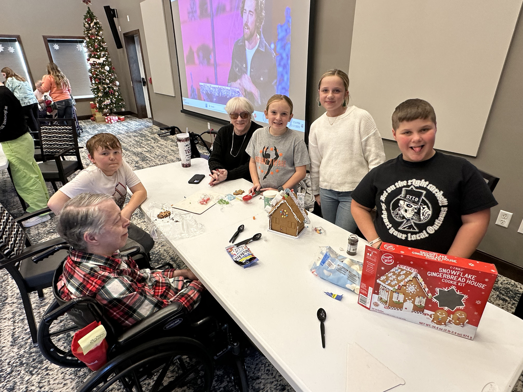 5th Grade Kindness Crew helping residents build gingerbread houses