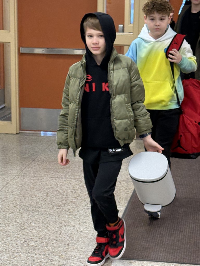 Student using a trash can as a backpack