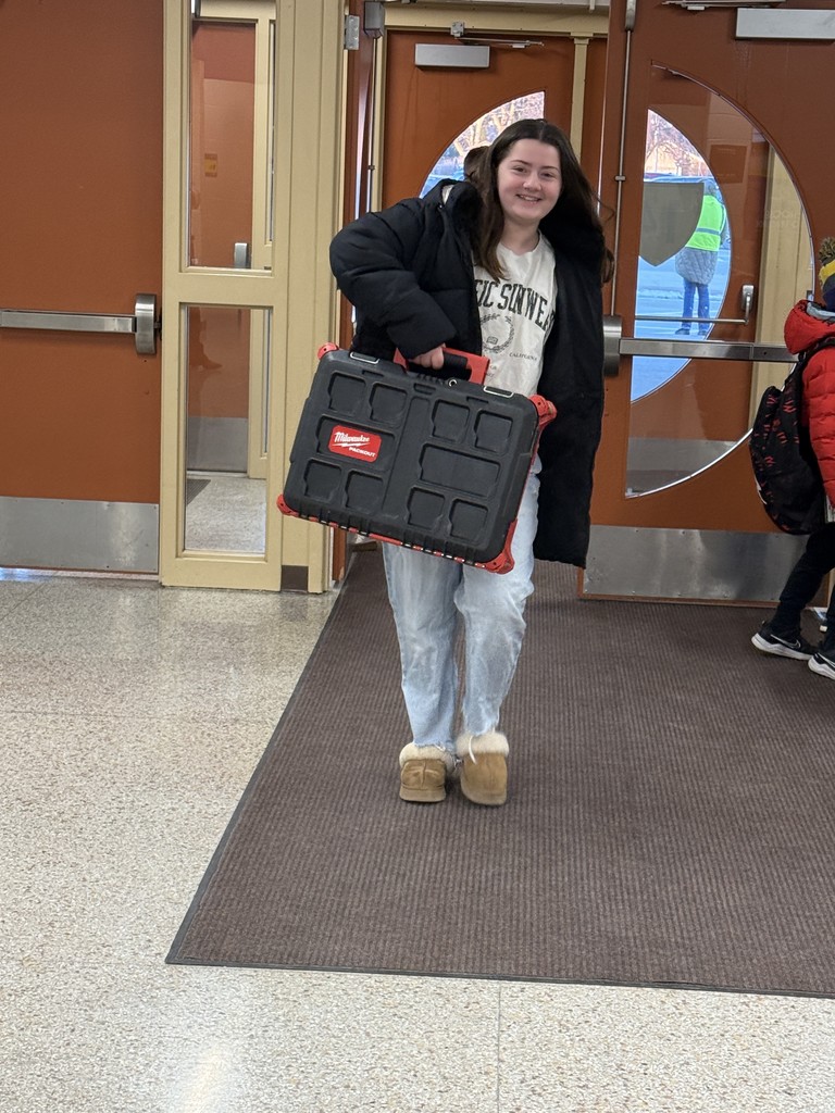 Student using a tool box as a backpack