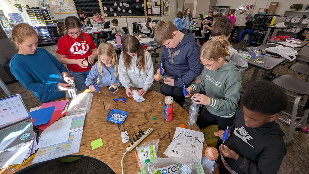 Students creating plastic bottle biography figures