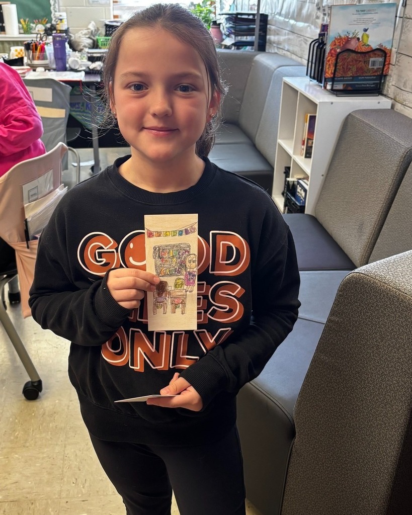 Student showing her bookmark that was chosen in the PTO Bookmark Design Contest