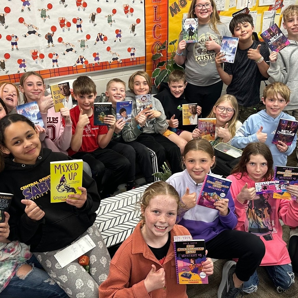 Students showing off their bookmarks and books given to them by the PTO