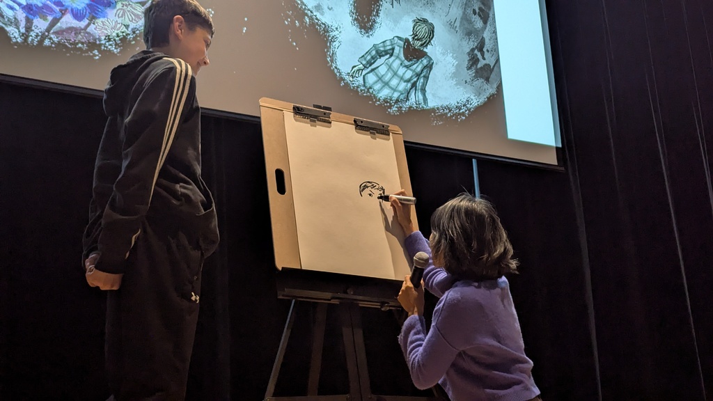 LeUyen Pham drawing a CDMS student during her presentation