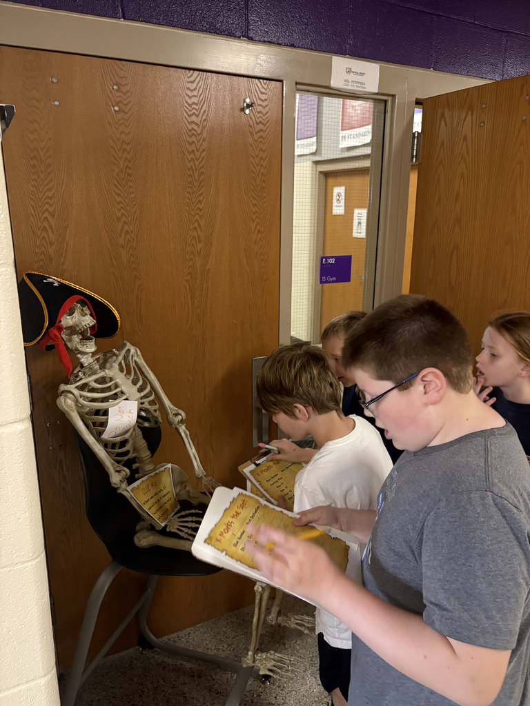 4th graders trying to solve clues that are part of the school-wide treasure hunt