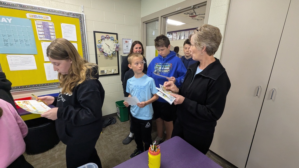 Mrs. Leuders handing out score sheets to students