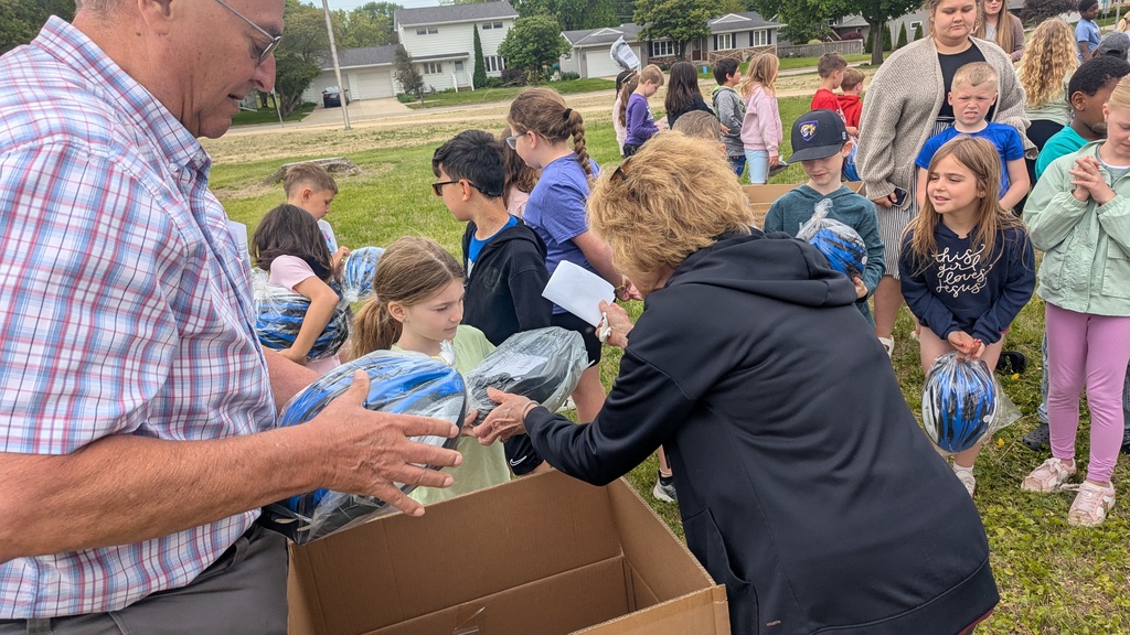 Second graders receiving their bike helmets from LincolnWay Community Foundation and Crossroads Health Foundation volunteers