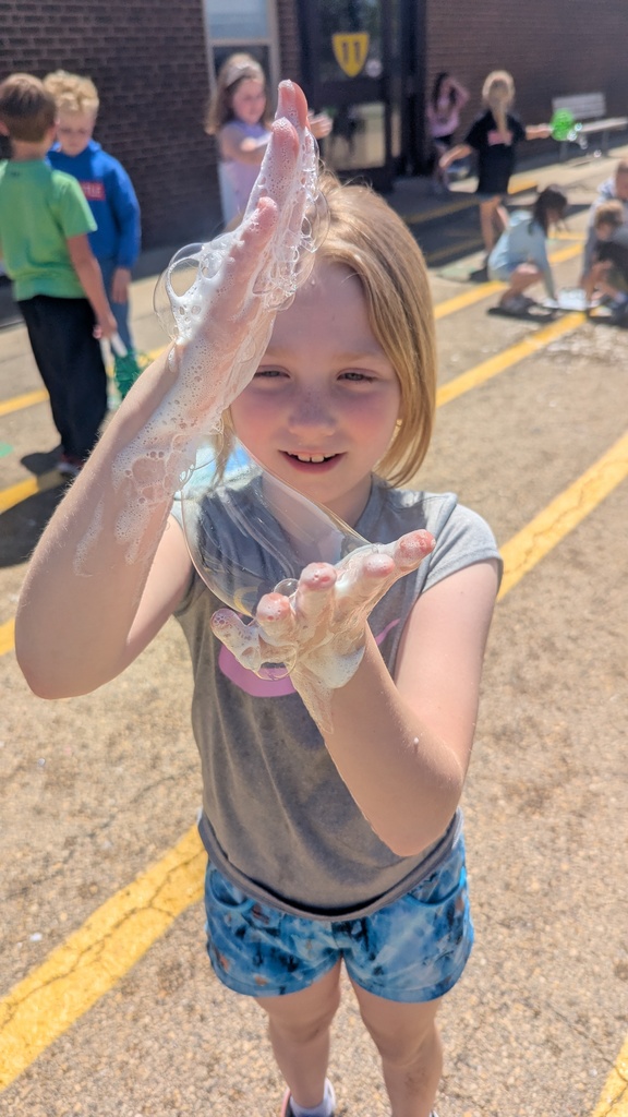 Second graders blowing bubbles using a special bubble recipe that uses corn syrup