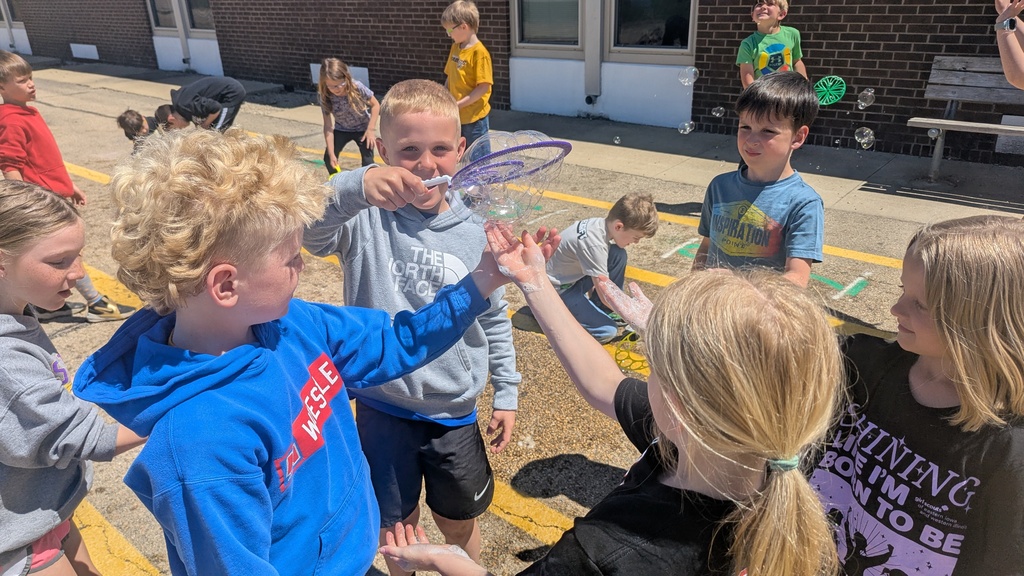 Second graders blowing bubbles using a special bubble recipe that uses corn syrup