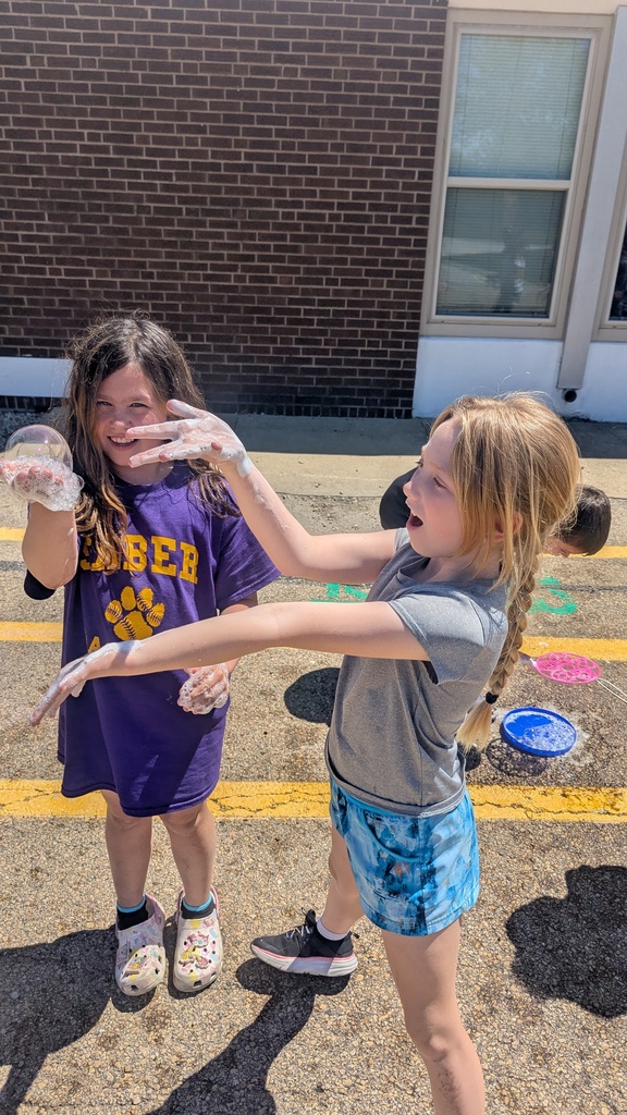Second graders blowing bubbles using a special bubble recipe that uses corn syrup