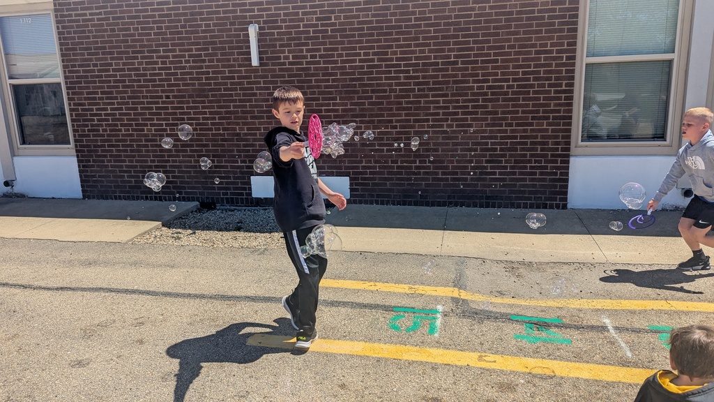 Second graders blowing bubbles using a special bubble recipe that uses corn syrup