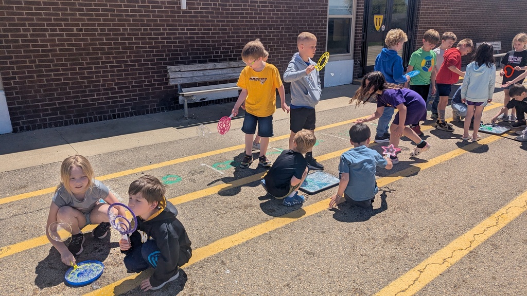 Second graders blowing bubbles using a special bubble recipe that uses corn syrup