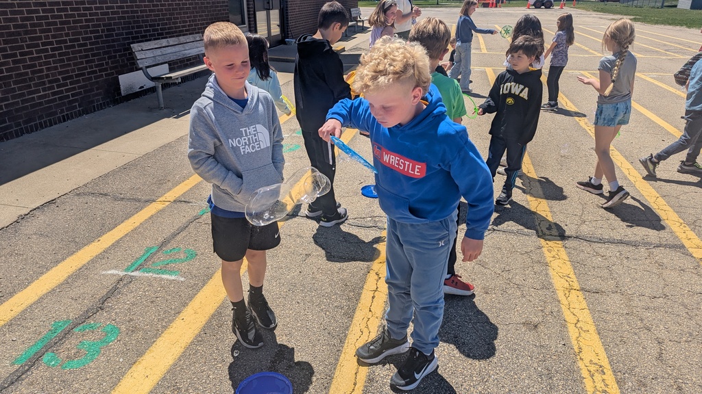 Second graders blowing bubbles using a special bubble recipe that uses corn syrup