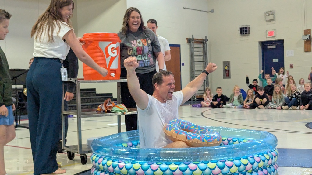 Ms. Wellman and Mrs. Keith dumping a bucket of ice water on Principal Mr. Miller