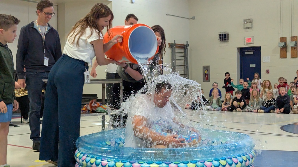 Ms. Wellman and Mrs. Keith dumping a bucket of ice water on Principal Mr. Miller